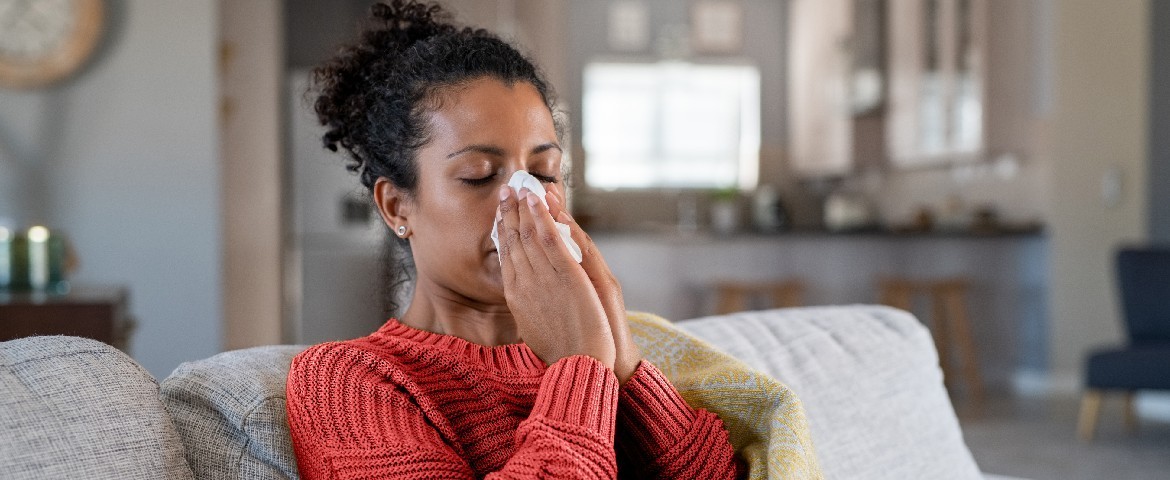 Une jeune femme en tenue hivernale se mouche