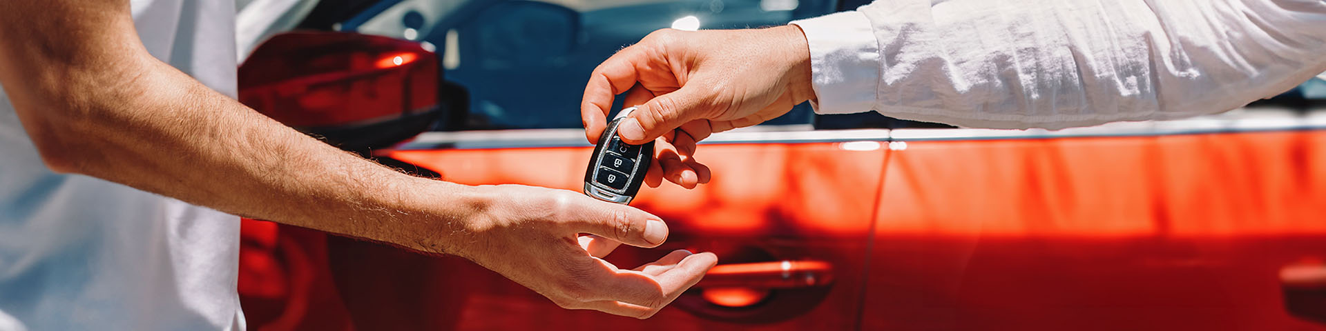 Une main qui tend une clé de voiture à une autre main