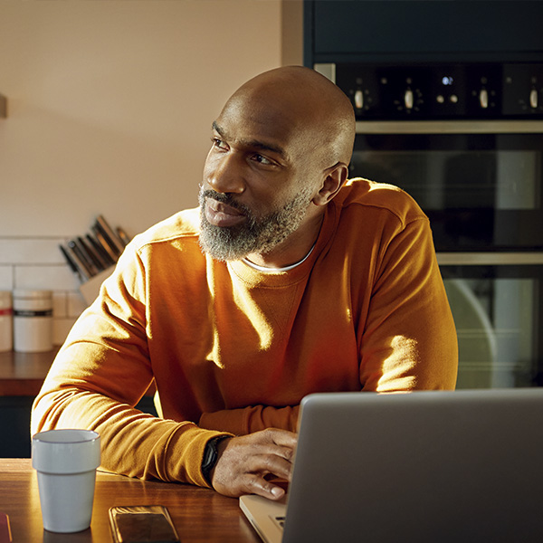 un homme chez lui devant un ordinateur
