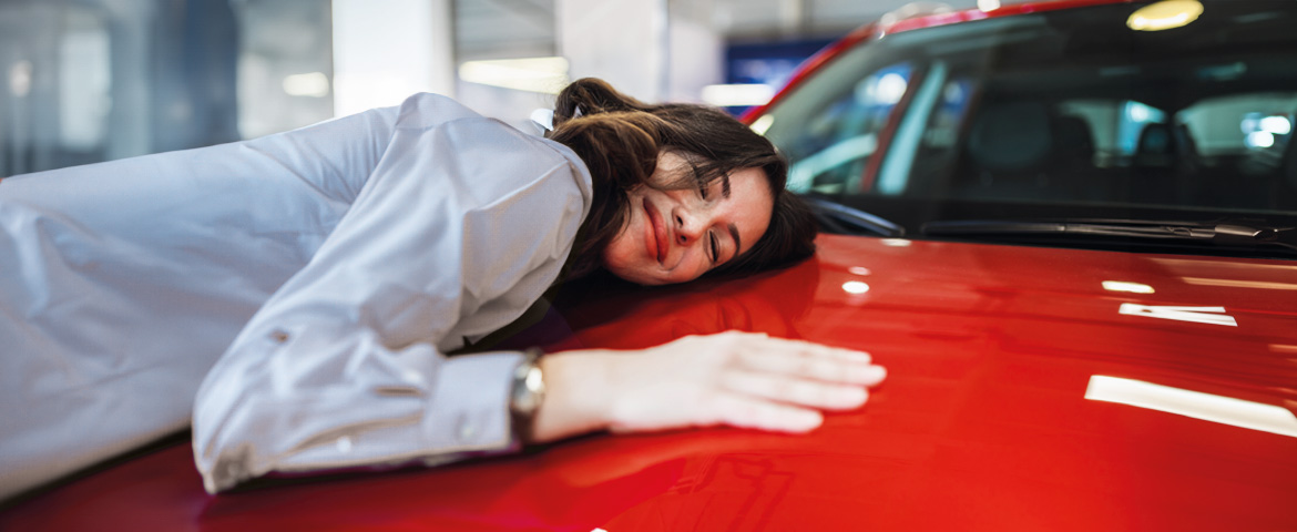 une femme fait un câlin à sa voiture