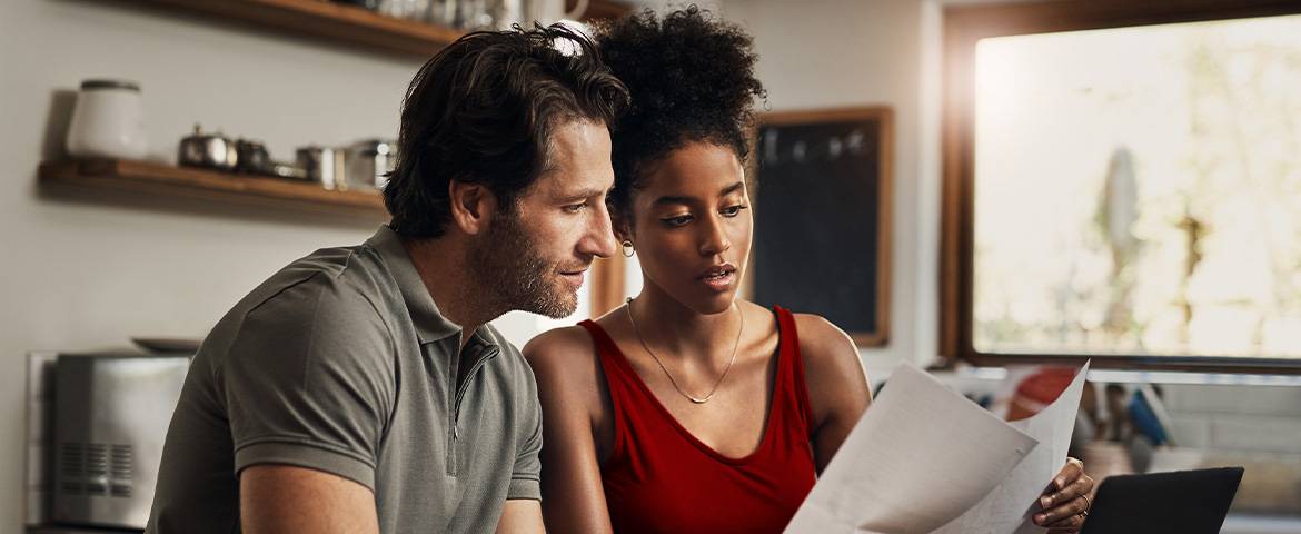 Un couple entrain de lire un papier dans leur cuisine 
