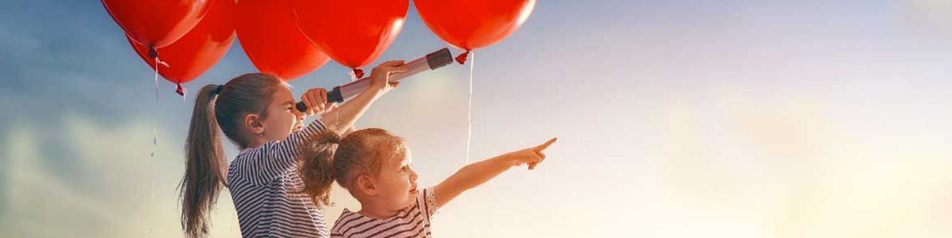 deux jeunes filles sous des ballons rouges