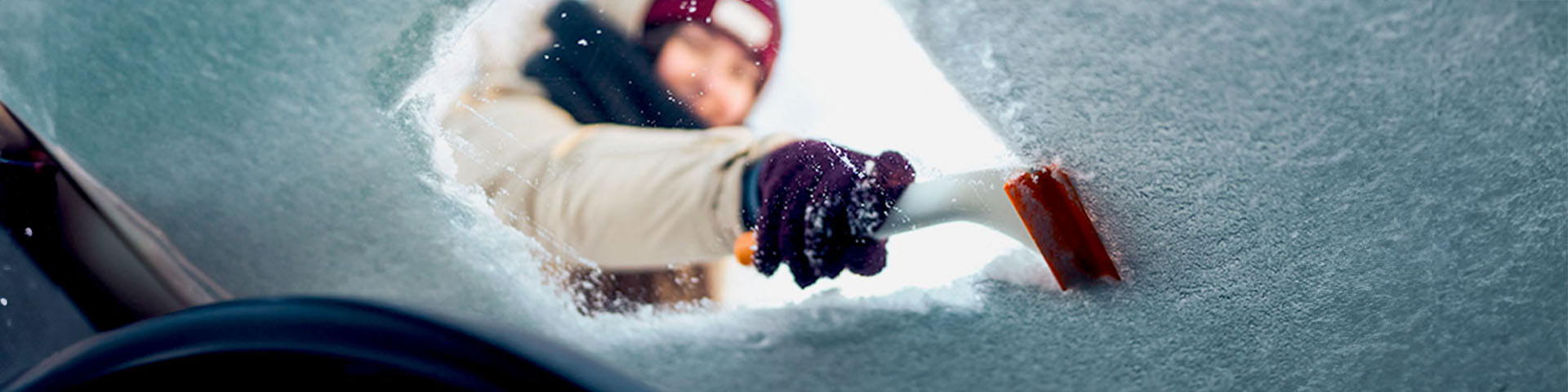 Une femme qui dégivre son parebrise 