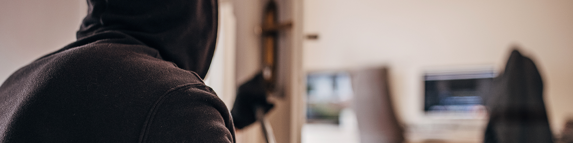 cambrioleur de dos essayant de crocheter une porte