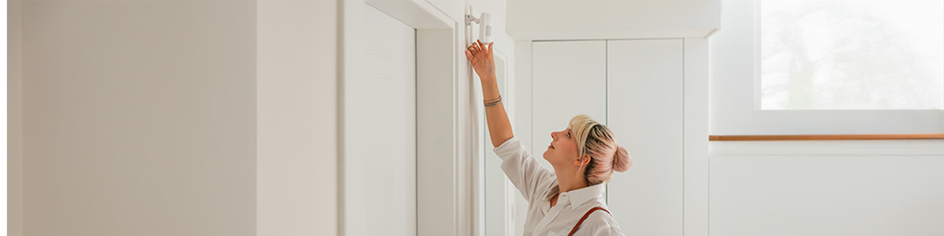 femme dans une maison vérifiant son alarme