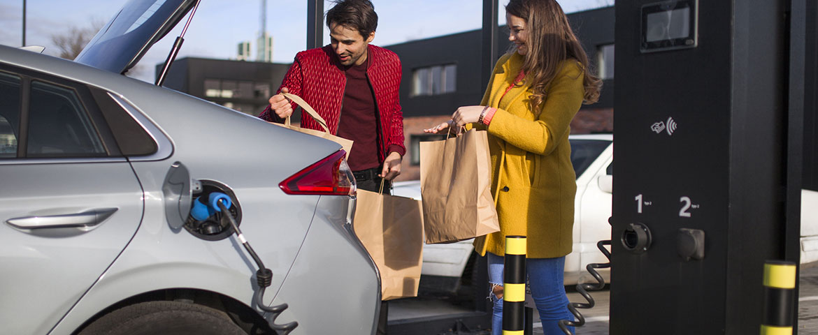 Un homme et une femme en train de charger des courses dans une voiture