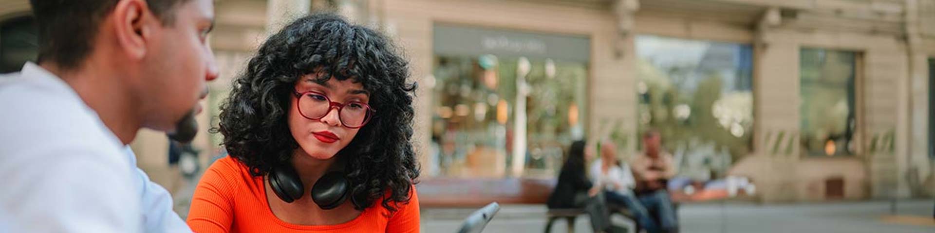 Jeune femme regardant son portable dans la rue (article sur les cryptomonnaies)