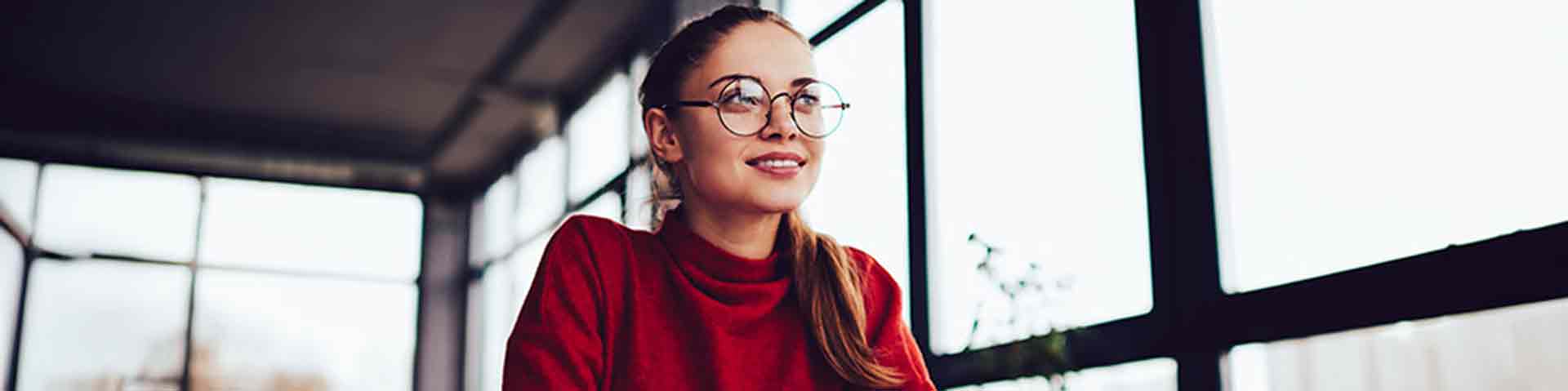 une femme à lunettes avec un pull rouge
