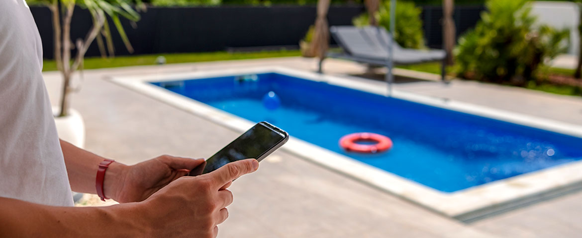 Un homme sur son téléphone à côté sa piscine