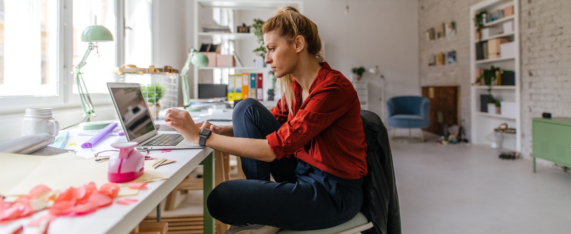 Une femme assise devant son ordinateur