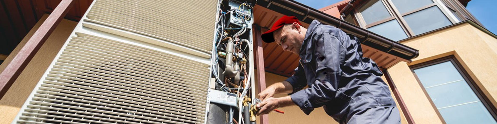 Un installateur de pompe à chaleur devant une maison
