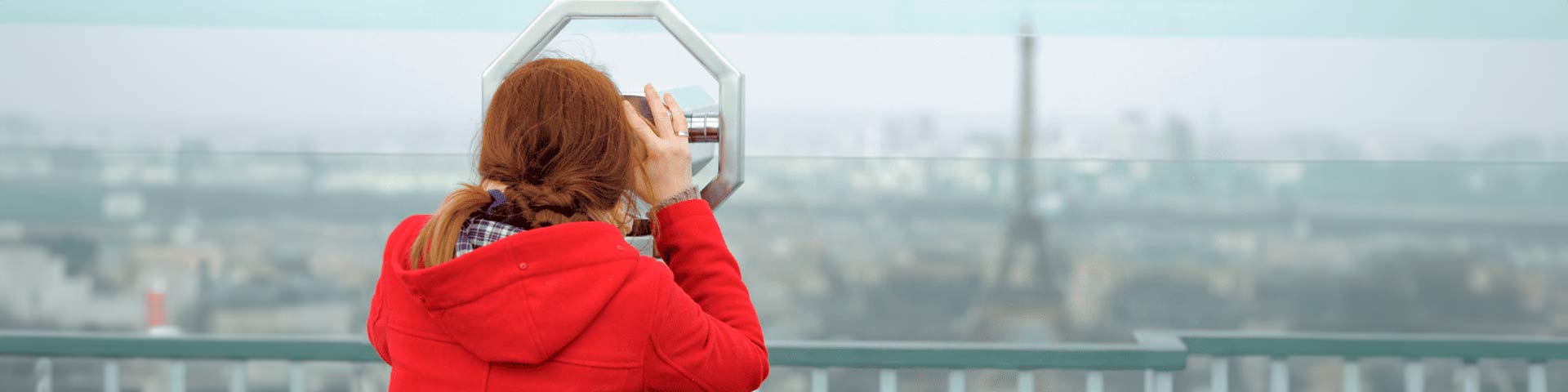 Une femme qui regarde la tour Eiffel avec des jumelles