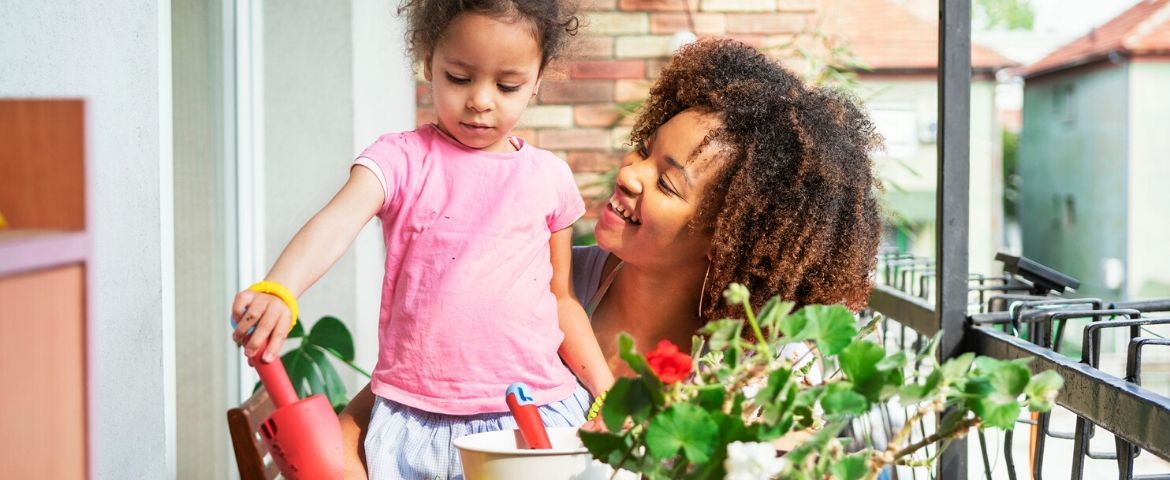 Une mère et sa fille qui jardinent sur leur balcon