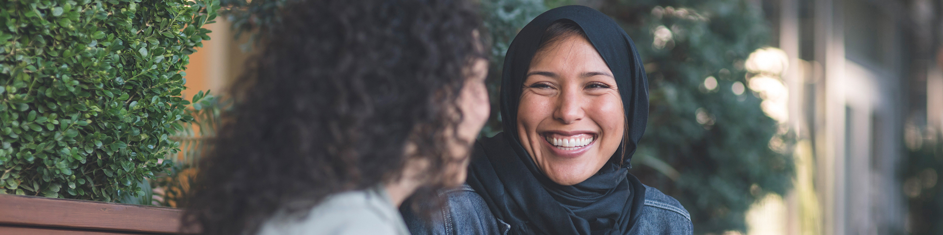 femme portant le hijab suriant à une autre femme