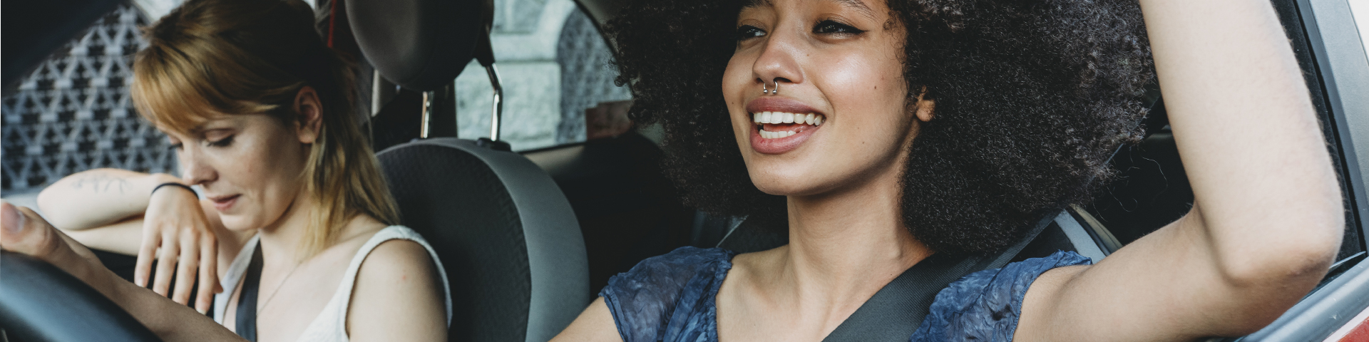 femme souriante au volant d'une voiture