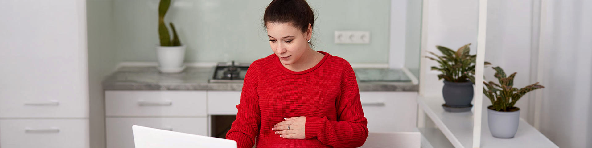 Une femme enceinte qui consulte son ordinateur 