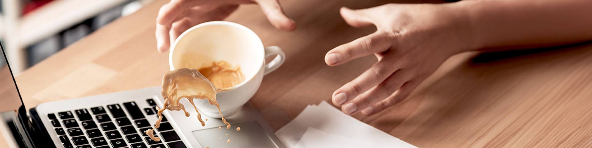 Une personne qui renverse un café sur un ordinateur
