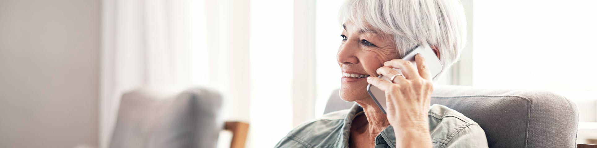 Femme aux cheveux gris téléphonant sur son mobile