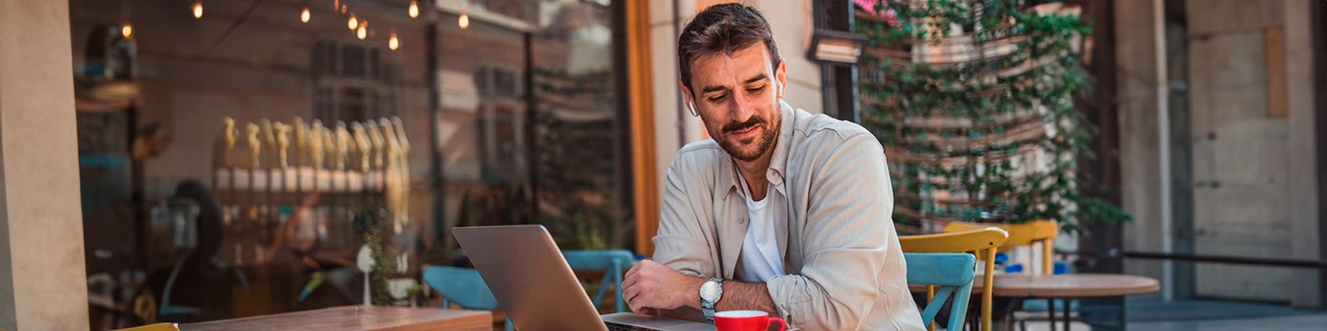 un homme en terrasse devant un ordinateur