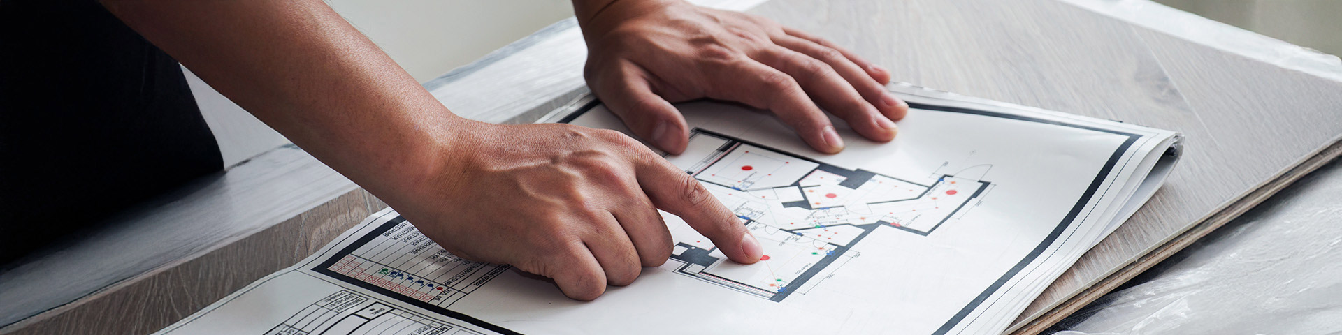 Mains posées sur le plan d'une maison à construire