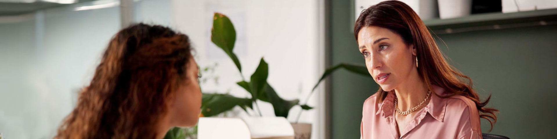 Deux femmes discutent de part et d'autre d'un bureau