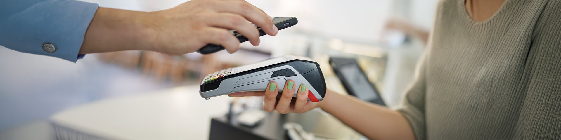 une femme tient un terminal de paiement dans la main