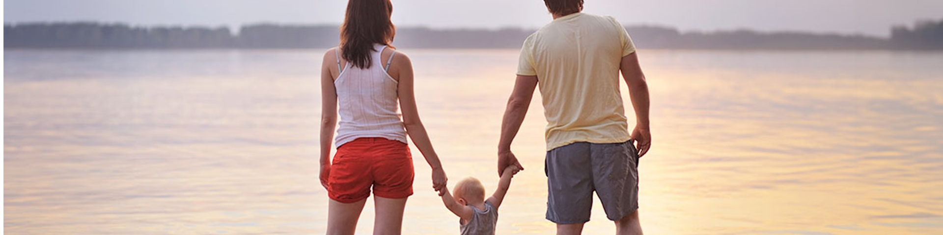 un couple et son enfant face à l'ocean
