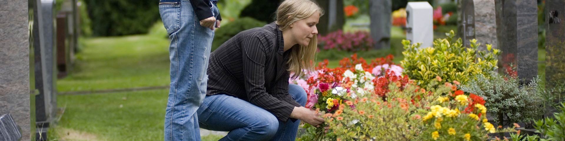 Jeunes femmes entretenant une tombe fleurie