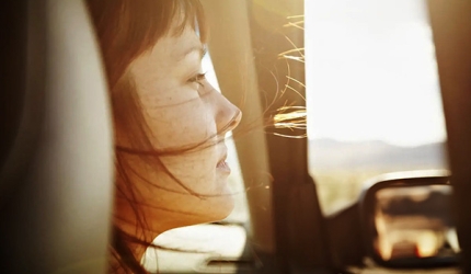 une femme qui regarde par la fenêtre de sa voiture