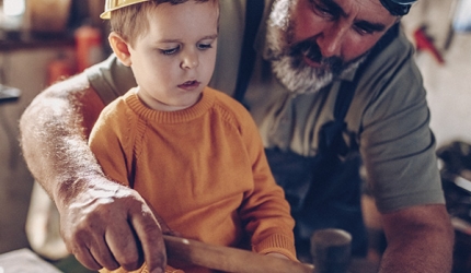 un homme et son petit fils qui travaillent dans un atelier