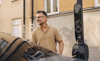 un homme devant sa voiture électrique