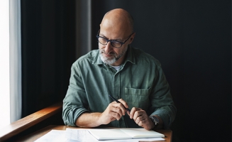 un homme qui regarde des documents l'air sérieux
