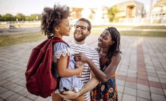 une jeune fille et ses parents devant l'école