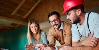 un couple et un artisan dans une maison en rénovation
