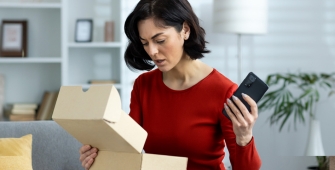 Une femme qui ouvre un colis dans son salon