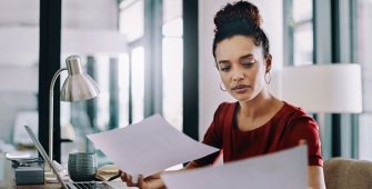 Une femme dans des bureaux d'entreprise qui lit des documents