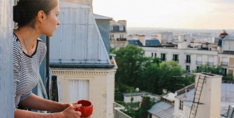 une femme au balcon d'un immeuble