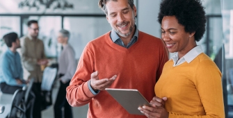 Un homme et une femme entrain d'échanger dans un open space
