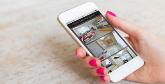 Une femme visualisant les caméras de sa maison à l'aide de son smartphone