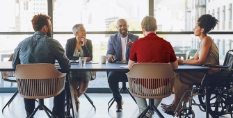 des employés autour d'une table dont une femme en fauteuil roulant