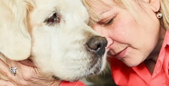 femme triste tenant la tête de son chien dans ses bras