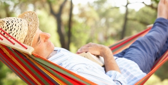 Un homme avec un chapeau de paille allongé dans un hamac