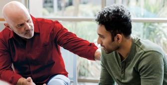 Un homme qui pose sa main sur l'épaule d'un autre homme