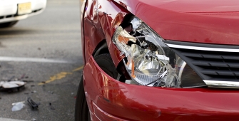 un voiture rouge avec un phare cassé