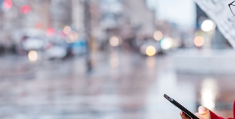 Une femme dans la rue qui regarde son téléphone