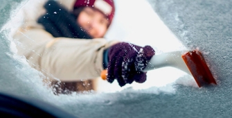 Une femme qui dégivre son parebrise 