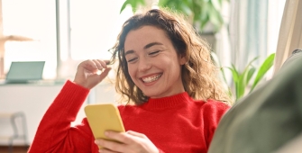 Femme souriant face à son portable