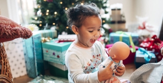 Une fille qui ouvre ses cadeaux sous le sapin