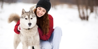 Une femme et son chien husky dans la neige