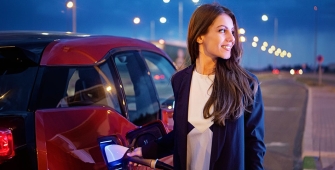 Une femme en train de mettre de brancher sa voiture électrique